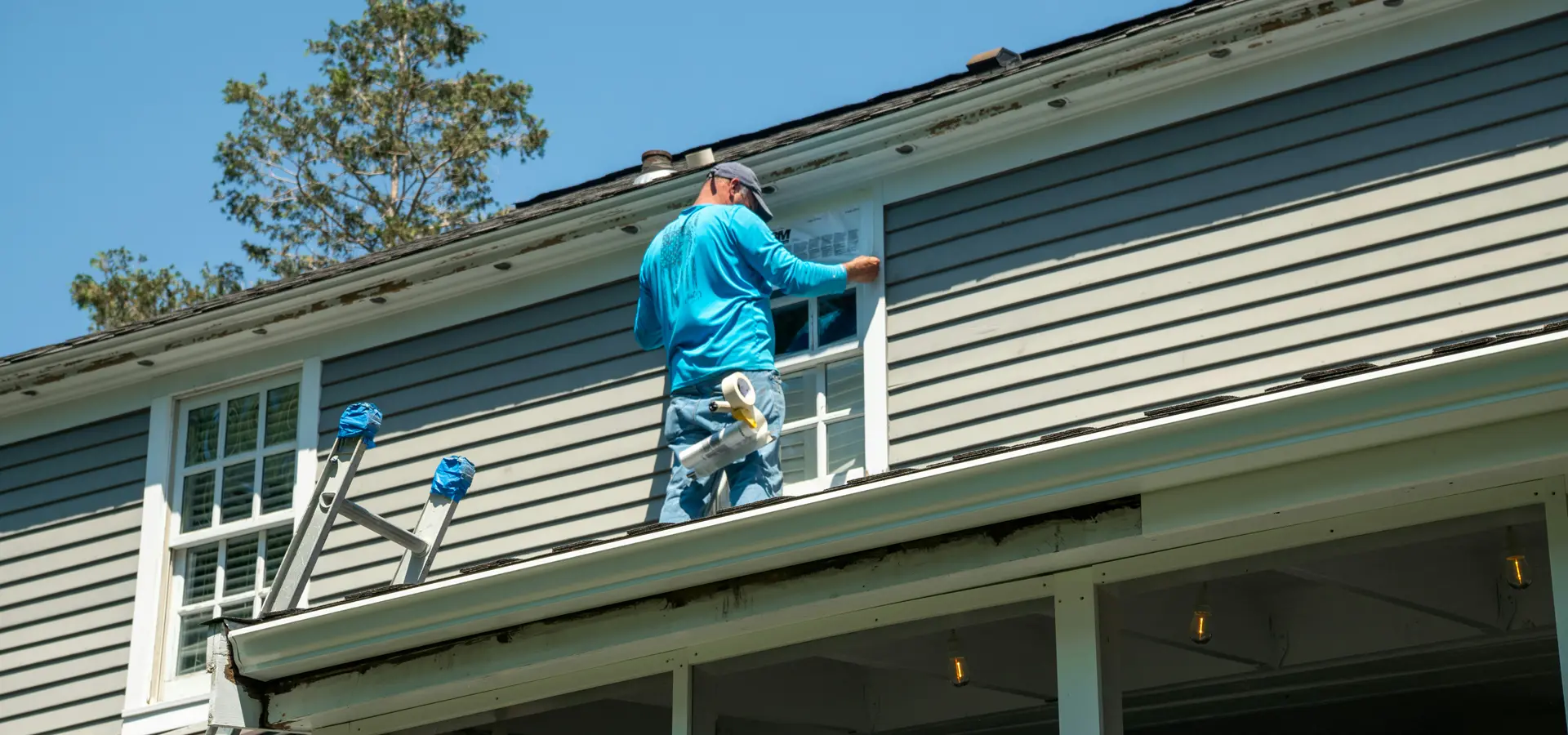 Perth painter applying exterior paint to weatherboard cladding and window frames