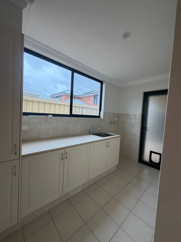 Repainted laundry walls and ceiling above white cabinetry in a Canning Vale home