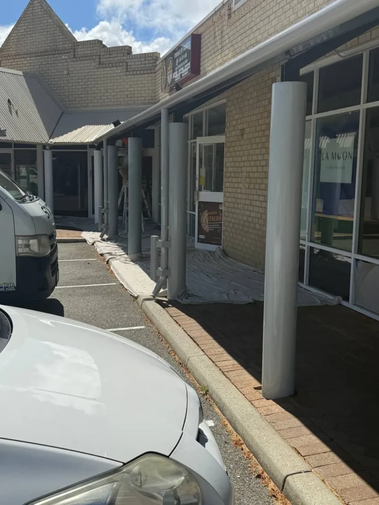Repainted verandah posts along the shopfront walkway of a Kardinya shopping strip